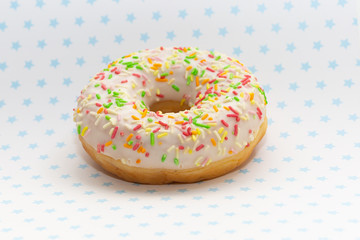 donut on white with blue stars background, close up view