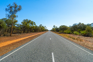 Fototapeta na wymiar an australian highway leads through the middle of the outback
