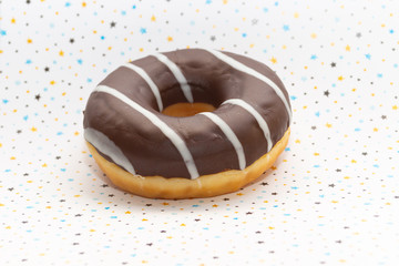 donut on white with colored stars background, close up view