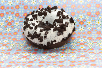 donut on purple with red flowers background, close up view