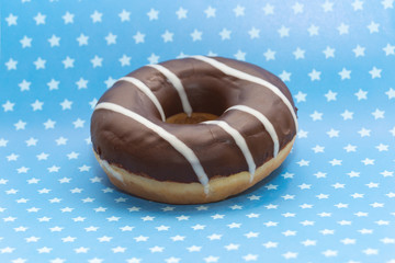 donut on blue with white stars background, close up view
