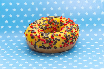 donut on blue with white stars background, close up view