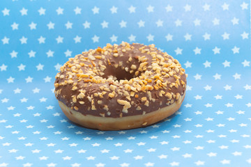 donut on blue with white stars background, close up view
