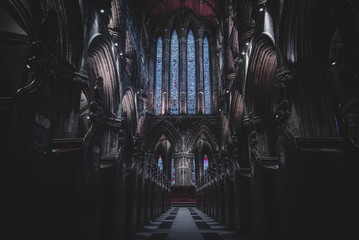GLASGOW, SCOTLAND, DECEMBER 16, 2018: Magnificent perspective view of interiors of Glasgow Cathedral, known as High Kirk or St. Mungo, with huge stained glasses. Scottish Gothic architecture. - obrazy, fototapety, plakaty