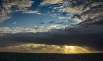 Fototapeta premium A sunrise produces shafts of light that trace across the Atlantic Ocean off the Cornish coast England,UK