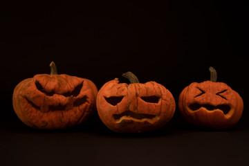 Calabazas de halloween con expresiones terrorificas y fondo de luces