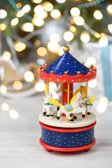 Close-up of musical carousel with horses. Blue, red, white merry go round. Toy. Vintage carousel, made from solid wood. Winter, Christmas, New Year decoration. Isolated on white background. Copy space