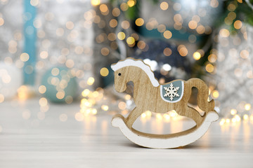 Close-up of Wooden horse - Christmas tree decoration on the Holiday background.  Christmas lights - snowflakes. Greeting card with new year decorations. Space for text, copy space. 