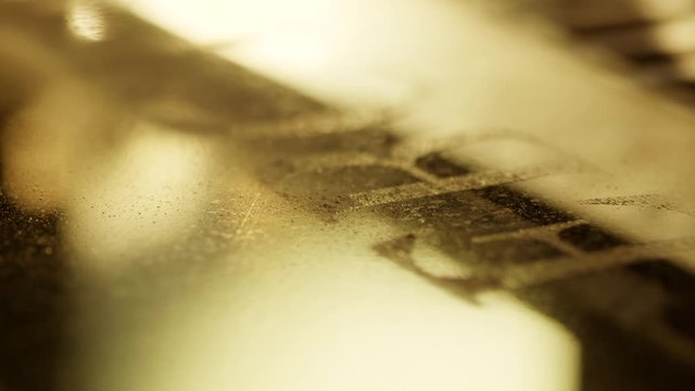 View of automated carving machine functioning and engraving letters and patterns on surface of dark granite block dedicated for memorial stones or headstone.