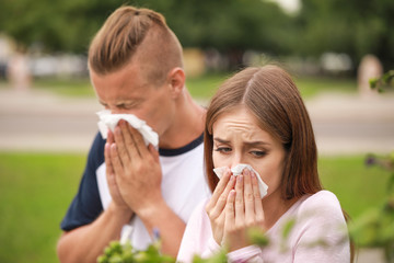 Young couple suffering from allergy outdoors