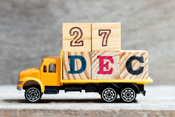Truck hold letter block in word 27dec on wood background (Concept for date 27 month December)