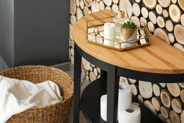Tray with houseplant, candle and aroma diffuser on table in bathroom