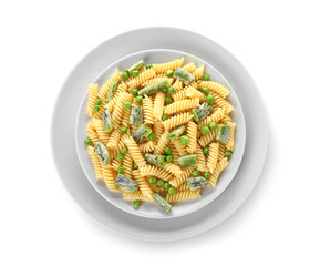 Plates with tasty pasta and vegetables on white background