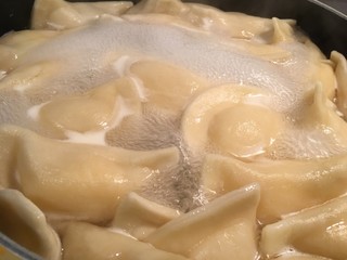 Pierogies boiled in a pot of water