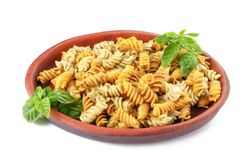 Plate with tasty pasta and pesto sauce on white background
