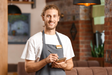 Young male waiter in restaurant