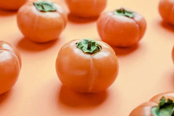 Ripe persimmons on color background