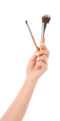Female hand with makeup brushes on white background