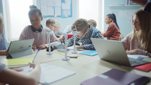 In the Elementary School: Class of Brilliant Young Children Work as a Team Using Tablet Computers to Program Wind Turbines