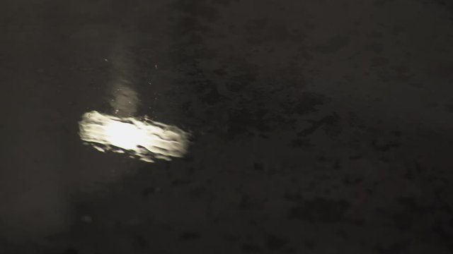 Light reflections in a pool of water at night at business district in Paris, slow steadicam movement close-up. Futuristic modern building.