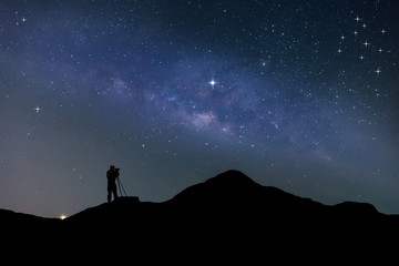 Traveler Man Silhouette Stand Top Mountain.Panorama blue night sky milky way and star on dark background.Universe filled , nebula and galaxy with noise and grain.