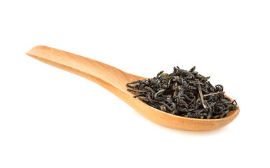 Dry green tea leaves in wood spoon on white background