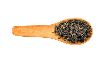 Dry green tea leaves in wood spoon on white background