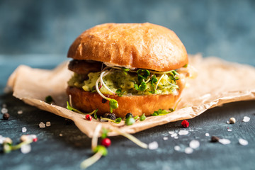 Fresh tasty burgers with roasted chicken, potato, micro greens and different herbs on the rustic...