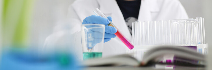 A male chemist holds test tube of glass