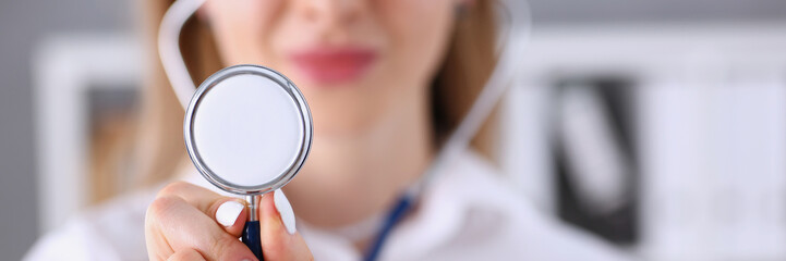 Beautiful smiling female doctor hold in hand stethoscope head
