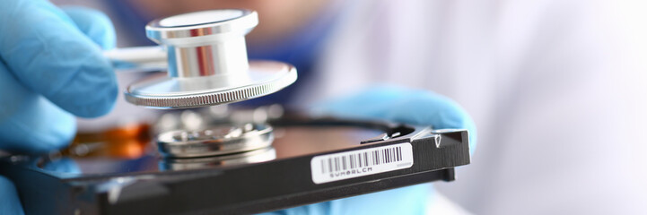 male repairman wearing blue gloves holding stethoscope on hard
