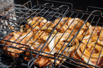 Meat on the grill. BBQ pork marinated with onions on the coal.
