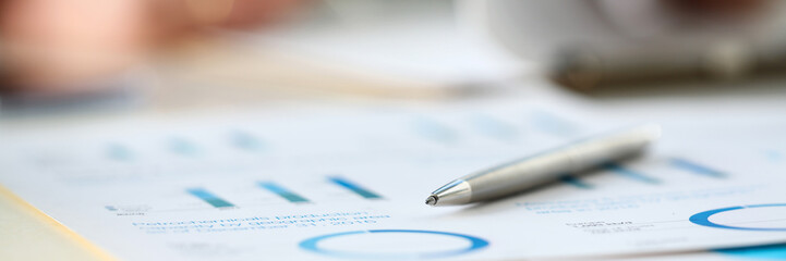 Silver pen lie at important paper on table in office