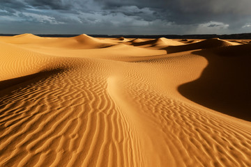 Sahara sand dunes with stormy, cloudy sky at Erg Lihoudi.
