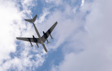 Military aircraft in the sky against the clouds above us.