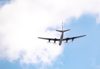 Military aircraft in the sky against the clouds above us.