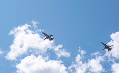 Military aircraft in the sky against the clouds above us.