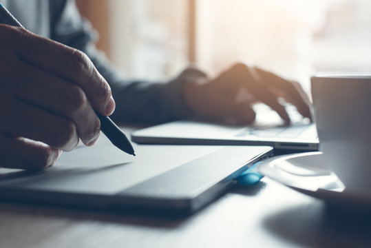 Designer working on laptop computer and pentablet