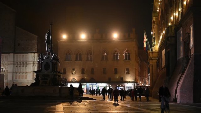 Bologna, Italy - October 2019 - Unknown people walk in the evening among the buildings and monuments of the historic city center, followed by the shadows of the night