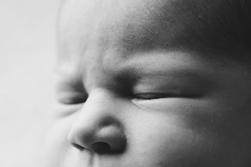 newborn baby's face close up: eyes, nose. concept of childhood, health care, IVF, hygiene