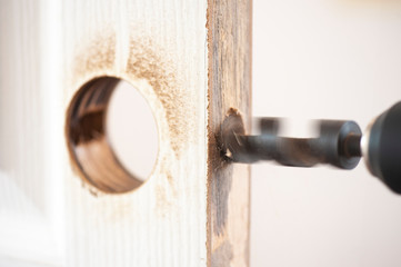 Intervention to secure a door of a home, Installation of the door lock, Wood processing, auger drilling, close up with copy space 