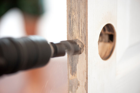 Intervention to secure a door of a home, Installation of the door lock, Wood processing, auger drilling, close up with copy space 