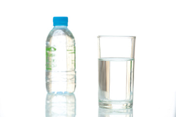 A glass of fresh drinking water. Close up purified fresh drink water on table and a fresh drinking water bottle on white background.