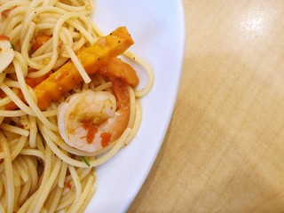 Thai food style (Spaghetti Pad Kee Mao), Spaghetti with shrimp, Mushroom and Vegetable in white bowl on wooden table, This food is most popular Thai food, Stir-fried Spicy Spaghetti Seafood