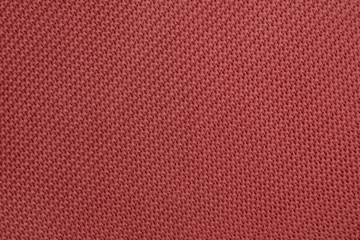 Knitted background of redwood color. Detailed diagonal knitting texture. Garter stitch pattern