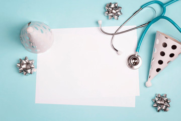 Doctor's or nurse day greeting card with stethoscope and festive caps on blue background.