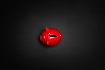 Red piggy bank on a black background. Saving, money, banking concept. Black friday sale concept.