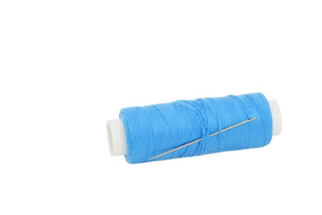 Sewing spool of light blue thread with silver color needle, isolated on white background. Copy space
