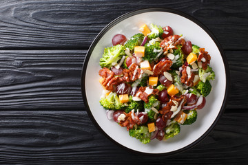 Holiday salad with broccoli, cheese, grapes, bacon, almonds and onions close-up in a plate. Horizontal top view