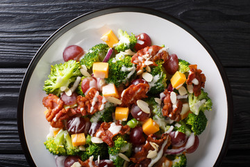 Serving of salad with broccoli, cheddar, grapes, bacon, almonds and onions close-up in a plate. Horizontal top view